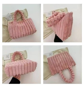 Detail view of pink plush tote bag with ribbed texture and fuzzy ball handle