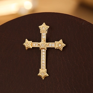 Macro view of gold-plated cross pendant with micro-pave zircons and star patterns