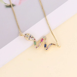 Close-up of snake pendant necklace with multi-colored cubic zirconia and 18K gold finish