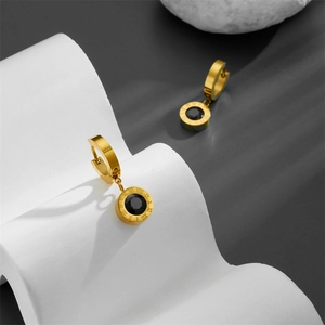 Gold Roman numeral huggie hoop earrings with black zircon pendant in a modern setting