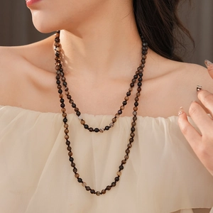 Detail of bohemian layered necklace with dark brown and black polished agate beads