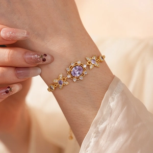 Detail of vintage gold bracelet with purple oval gemstone and zircon flower accents