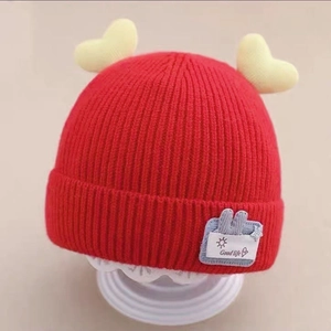Red knit baby hat with yellow hearts and cartoon rabbit patch for winter