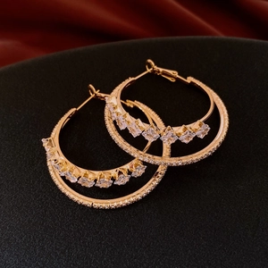 Detail view of double layer gold hoop earrings with sparkling cubic zirconia inlay