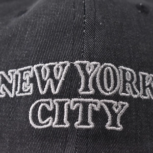 Black cotton baseball cap with white New York City embroidery and twill texture