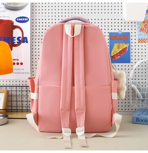 Details des pinkfarbenen Schulrucksacks mit gepolsterten Gurten und weißen Schnallen
