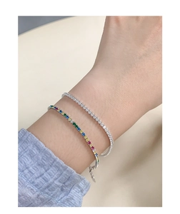 Detail of silver tennis bracelets with white and rainbow cubic zirconia on wrist
