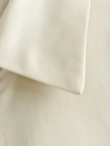 Primo piano del tessuto twill beige che mostra la trama dettagliata e la trama densa