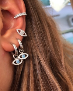 Close-up of silver Evil Eye earrings with blue zircon inlays and micro-pave ear cuff