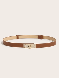 Macro shot of brown cross-grain leather belt with a gold rhinestone-encrusted turn-lock buckle