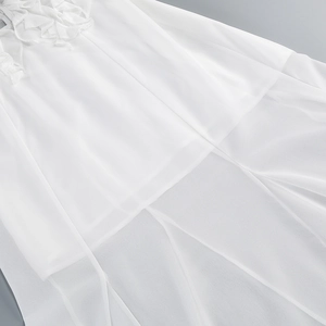 Detailansicht weißer Rüschenlagen eines figurbetonten Kleides aus leichtem Chiffon-Stoff