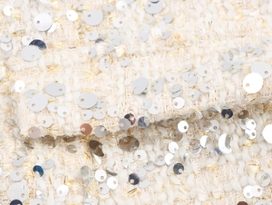 Gros plan sur le tissu bouclé tweed avec fils dorés et paillettes argentées brillantes