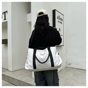 Large capacity white Oxford travel bag with black straps carried by model outdoors