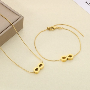 Detailed view of infinity pendant necklace and bracelet set in polished gold finish