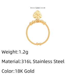 Detail of 18K gold stainless steel twisted ring featuring a hammered heart pendant