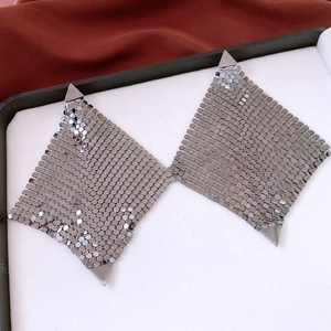 Détail macro du tissu en maille de paillettes métalliques argentées avec attaches triangulaires