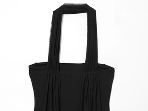 Detail of black halter neck dress with pleated mesh fabric and sheer paneling