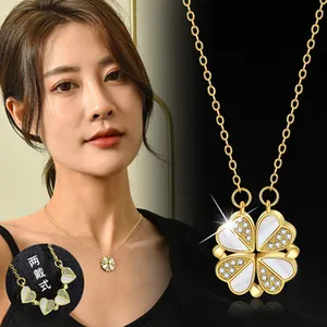 Detail of gold four-leaf clover necklace with shell inlay showing magnetic folding feature