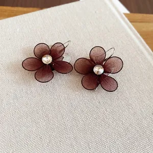 Brown mesh flower earrings with crystal center and silver hooks on vintage book