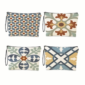 Set of four geometric pattern makeup bags with zippers and wrist straps on white background