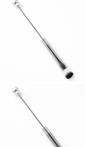 Detail of silver DIY beadable makeup brush with black and white fiber bristles and metal rod