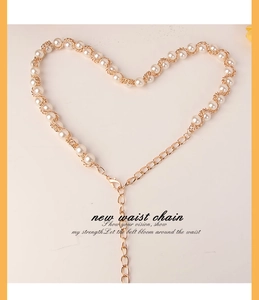 Elegant gold metal chain interwoven with white pearls arranged in a creative heart shape