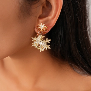 Detail view of rhinestone reindeer and snowflake earring on model ear for Christmas style