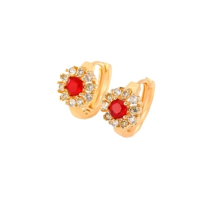 Elegant gold flower hoop earrings with red zircons and sparkling crystals on white background