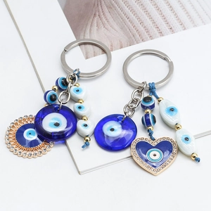 Detailed close-up of blue evil eye keychains with sun and heart crystal pendants