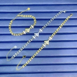 Detailed view of gold and silver heart bracelets with cubic zirconia on blue velvet