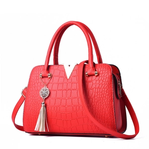 Elegant red crocodile texture handbag with gold V-detail and stylish tassel pendant