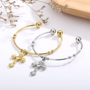 Elegant gold and silver titanium steel cross rose open bangles on wooden tray