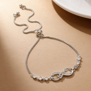 Close-up of silver infinity LOVE bracelet with pavé cubic zirconia and adjustable slide