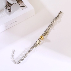 Detailed view of silver double-layer chain bracelet with golden orb and angel wings charm