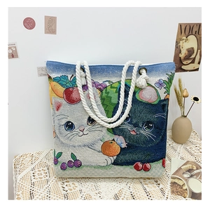 Detailed view of the jacquard fabric texture featuring cat and fruit illustrations on the tote
