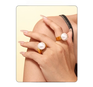 Close-up of elegant gold plated rings with large pearls on fingers for fashion styling