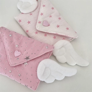 Detail of pink canvas mini coin purses with angel wings and heart-shaped buttons