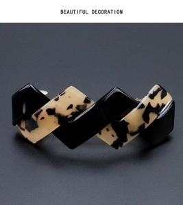 Detail of elegant black and tortoiseshell acetate hair clip with geometric serrated curve