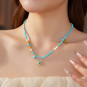 Gros plan du collier de perles bohème avec pendentif soleil et perles blanches sur mannequin