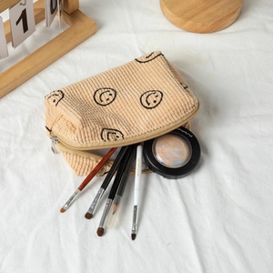 Detailed view of khaki corduroy makeup bag with embroidery and interior cosmetic storage