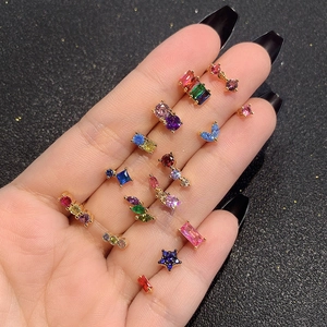 Detailed close-up of colorful zircon star and geometric stud earrings in 18K gold finish