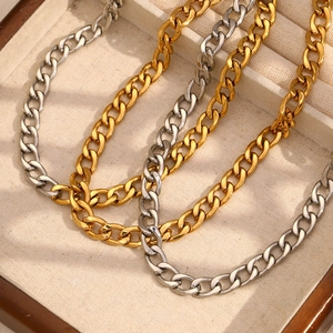 Polished Cuban chain necklaces in gold and silver finish on a wooden jewelry display