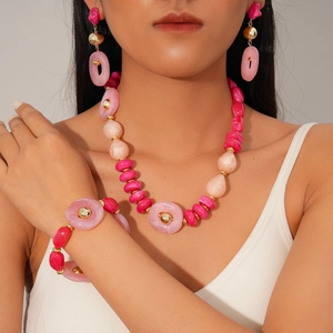 Bohemian style pink acrylic bead necklace set worn by model with gold metal spheres