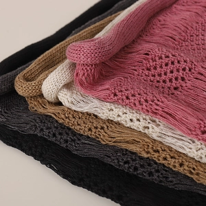Gros plan détaillé sur la texture tricotée ajourée avec franges en cinq coloris variés