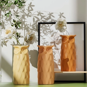 Detailed view of owl-shaped resin vases with geometric diamond facets in warm tones