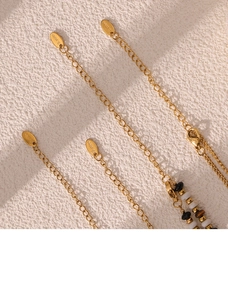 Close-up of golden stainless steel necklace with tiger eye beads and S.Steel hallmark