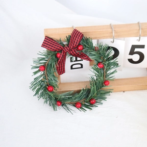 Christmas candle ring with pine needles, red berries and plaid bow for home decor