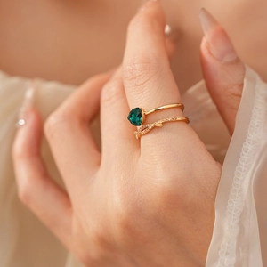 Détail d'une bague plaquée or 18 carats avec émeraude poire et diamants croisés élégants