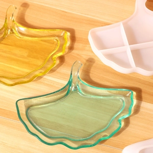 Moules en silicone en forme de feuille de ginkgo jaune et vert sur fond en bois