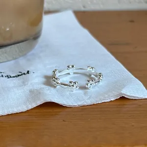Detailed view of 925 sterling silver floral adjustable open ring on a cozy table